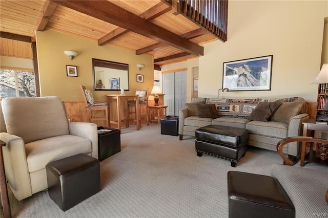 carpeted living room with beam ceiling and wooden ceiling