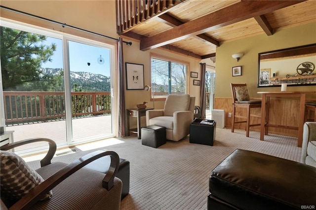 carpeted living room featuring wood ceiling, a mountain view, and beamed ceiling