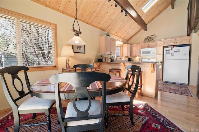 dining space with a skylight, light hardwood / wood-style floors, wood ceiling, beam ceiling, and rail lighting