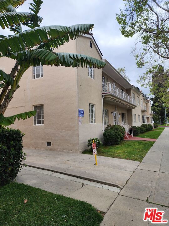 view of side of property featuring a balcony and a yard