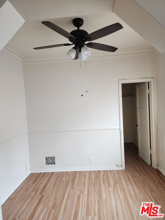 spare room with ornamental molding, light hardwood / wood-style flooring, and ceiling fan