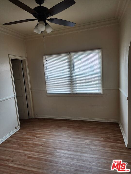 unfurnished bedroom featuring wood-type flooring, ceiling fan, and ornamental molding