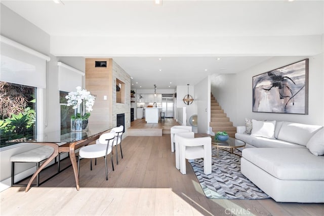 living room featuring a large fireplace and light wood-type flooring