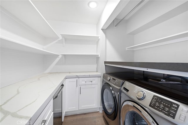 laundry area with cabinets, washing machine and dryer, and light wood-type flooring