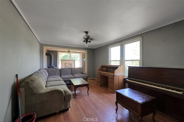 living room featuring light hardwood / wood-style floors, plenty of natural light, crown molding, and ceiling fan