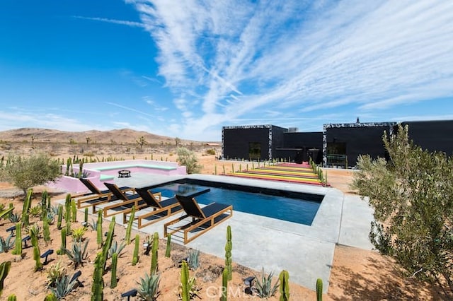 view of pool with a mountain view and a patio