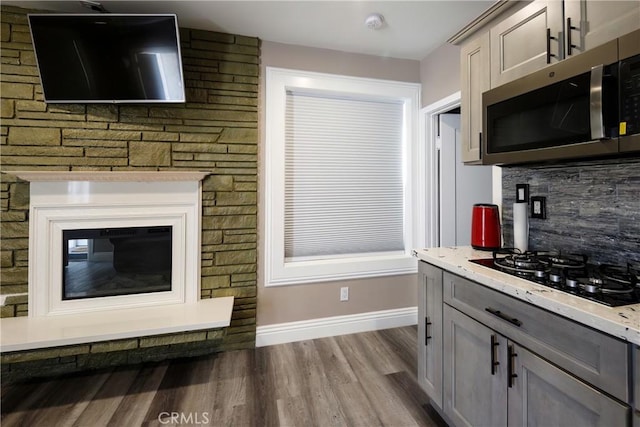 kitchen with black gas cooktop, light hardwood / wood-style flooring, tasteful backsplash, and gray cabinetry