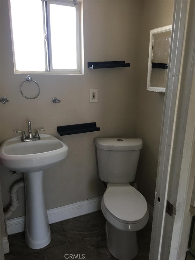 bathroom featuring tile patterned flooring, toilet, plenty of natural light, and sink