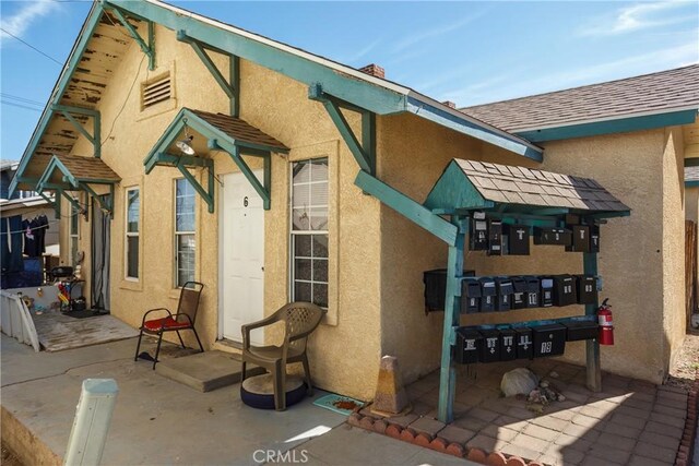 222 F St, Needles, CA 92363 - rear view of house featuring stucco siding, a patio, and a shingled roof