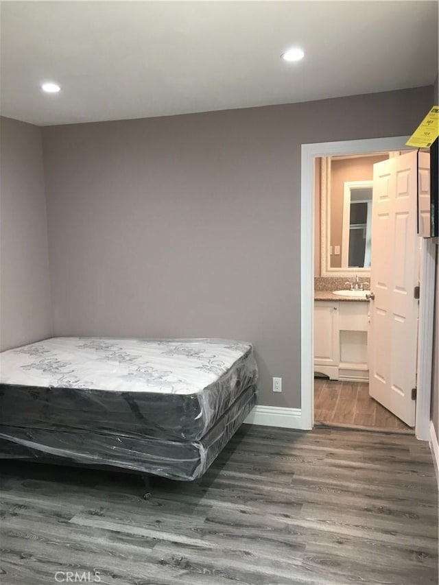 222 F St, Needles, CA 92363 - bedroom featuring a sink, wood finished floors, recessed lighting, baseboards, and connected bathroom
