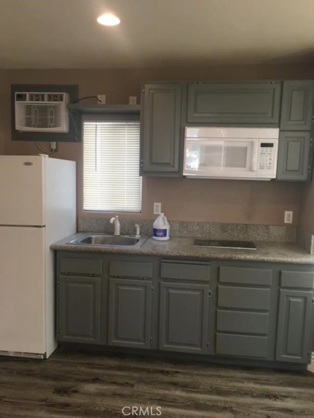 222 F St, Needles, CA 92363 - kitchen featuring white appliances, a sink, a wall unit AC, dark wood-type flooring, and recessed lighting