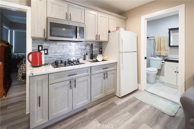 222 F St, Needles, CA 92363 - kitchen featuring stainless steel microwave, black gas stovetop, freestanding refrigerator, and light countertops