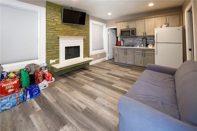222 F St, Needles, CA 92363 - living room featuring light wood finished floors, a stone fireplace, and recessed lighting