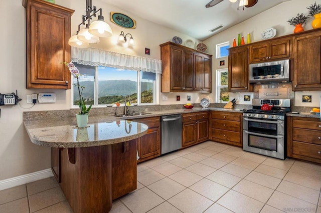 kitchen with pendant lighting, sink, light tile patterned floors, kitchen peninsula, and stainless steel appliances