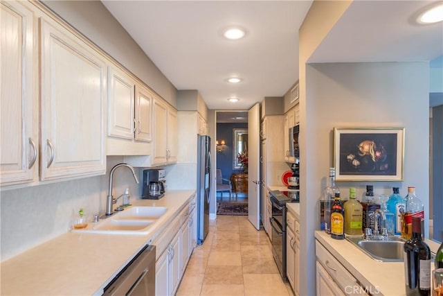 kitchen with appliances with stainless steel finishes, light countertops, a sink, and recessed lighting