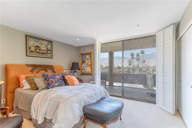 bedroom with access to outside, a wall of windows, recessed lighting, and light colored carpet