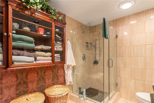 bathroom with a shower stall and toilet