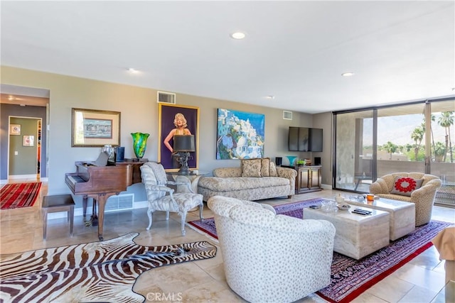 living area with baseboards, visible vents, a wall of windows, and recessed lighting