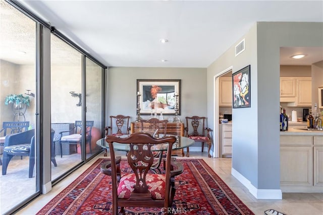 dining room with light tile patterned floors, visible vents, and baseboards