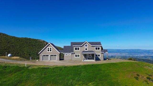 rear view of house with a garage and a lawn