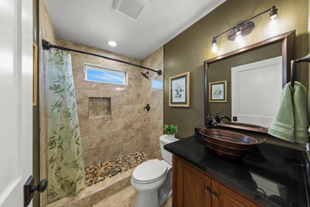 bathroom with a textured ceiling, toilet, vanity, and a shower with curtain