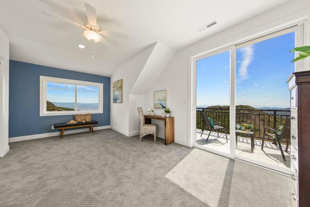 interior space featuring ceiling fan, light carpet, and lofted ceiling