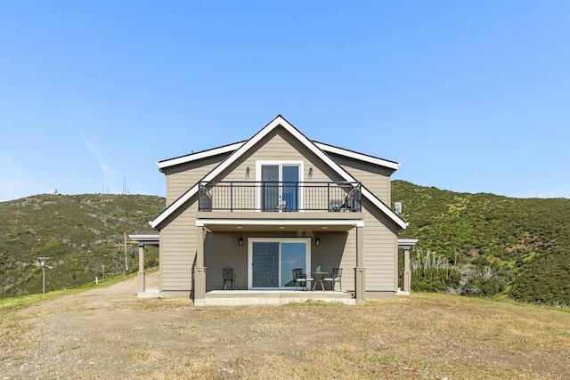 rear view of property with a patio area and a balcony