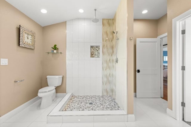 bathroom with toilet, tile patterned floors, and a tile shower