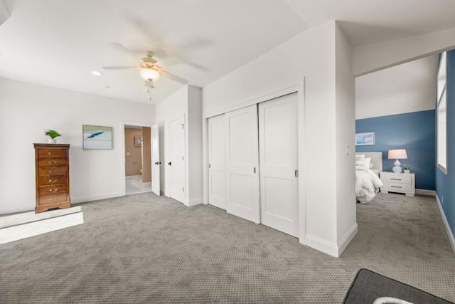 unfurnished bedroom featuring ceiling fan, light colored carpet, and a closet