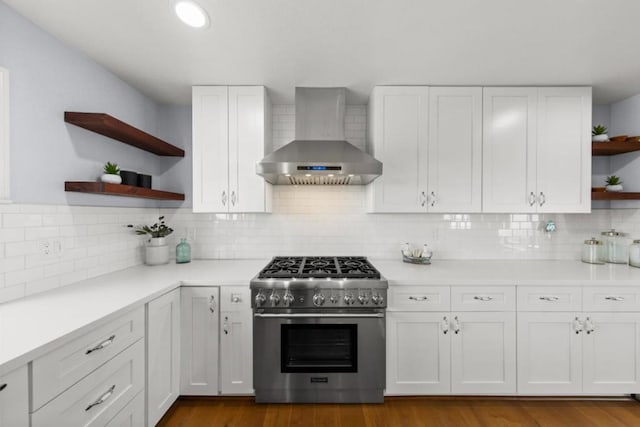 kitchen featuring white cabinetry, wall chimney range hood, high end range, and tasteful backsplash