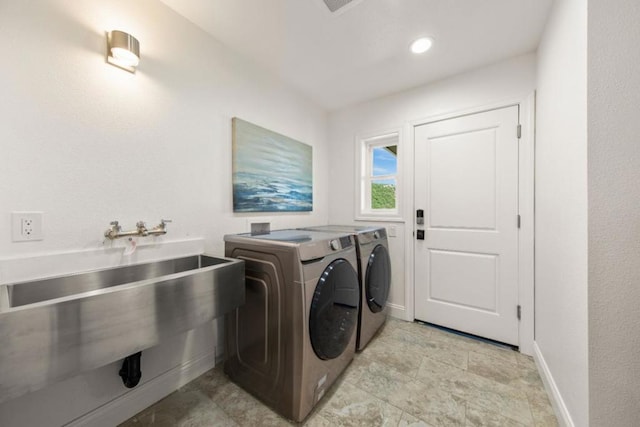 laundry area with separate washer and dryer and sink