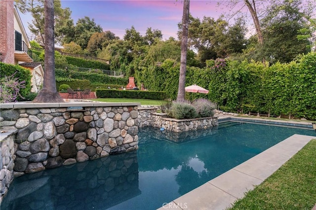 view of pool at dusk