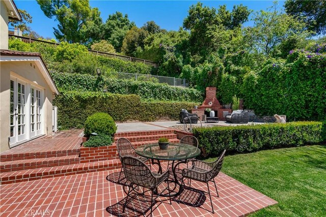 view of patio with french doors and an outdoor brick fireplace