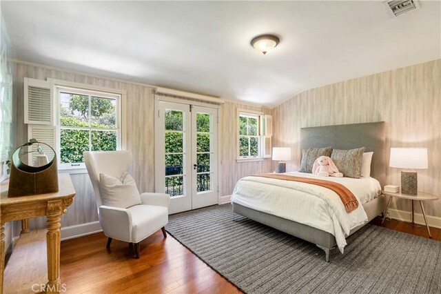 bedroom with dark hardwood / wood-style floors and access to outside