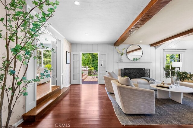 living room with beamed ceiling, dark hardwood / wood-style flooring, and wooden walls