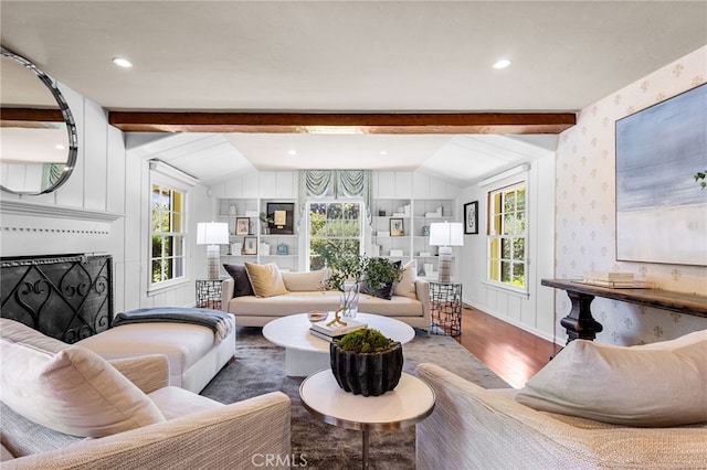 living room featuring built in shelves, vaulted ceiling with beams, and hardwood / wood-style flooring