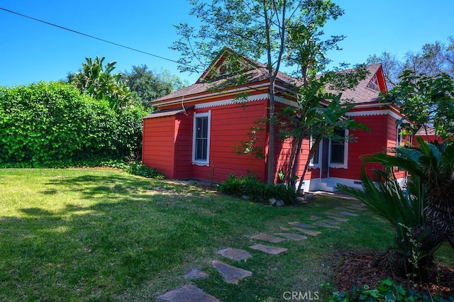 view of side of home with a yard