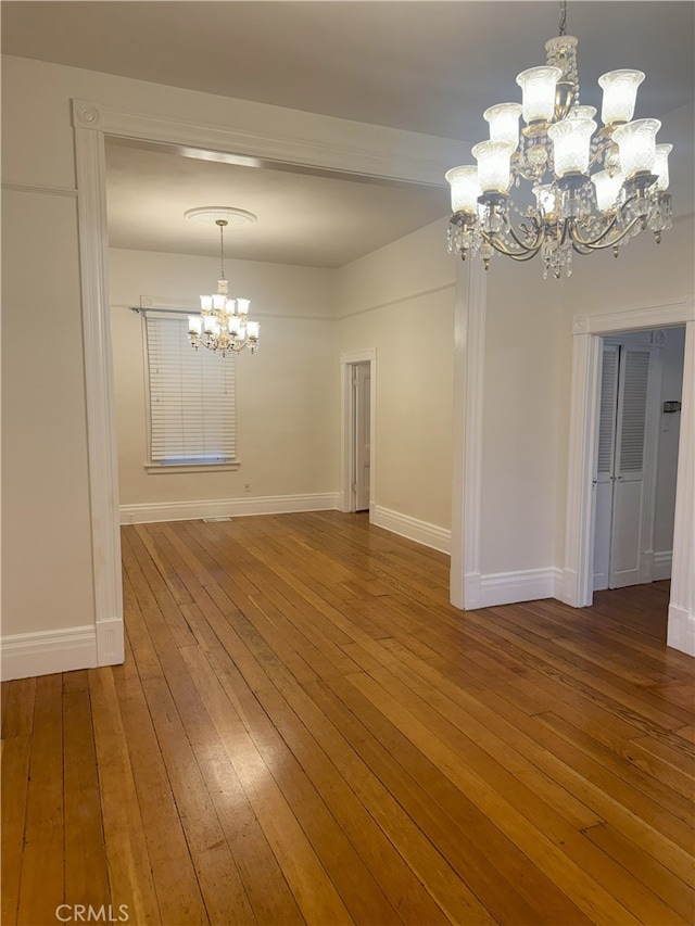 unfurnished dining area featuring a chandelier and hardwood / wood-style floors