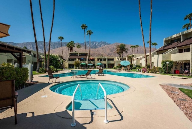 view of swimming pool featuring a mountain view and a patio area