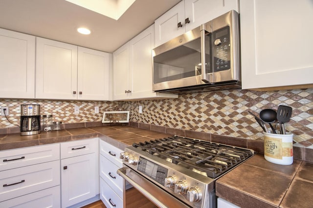 kitchen featuring white cabinetry, appliances with stainless steel finishes, and tasteful backsplash