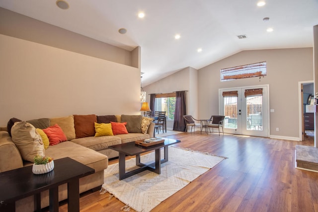 living room featuring french doors, hardwood / wood-style flooring, high vaulted ceiling, and a healthy amount of sunlight