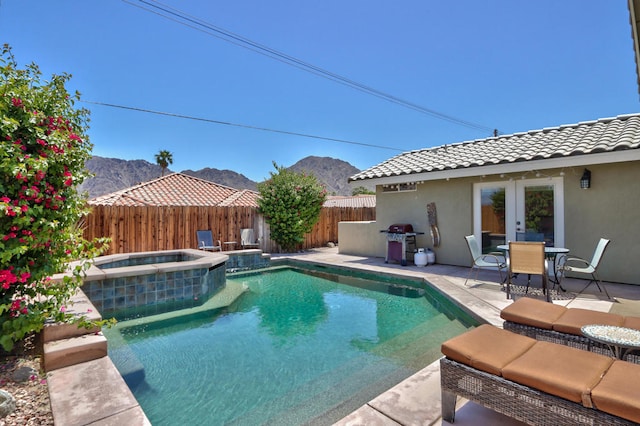 view of pool featuring an in ground hot tub, a mountain view, french doors, and a patio area