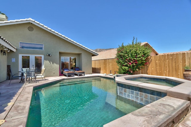 view of swimming pool with a patio area, an in ground hot tub, and french doors