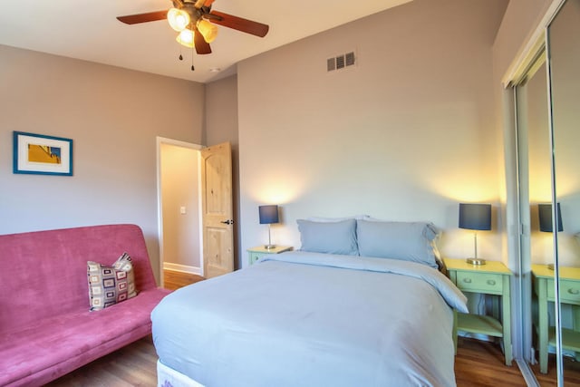 bedroom featuring dark hardwood / wood-style floors, ceiling fan, and a closet