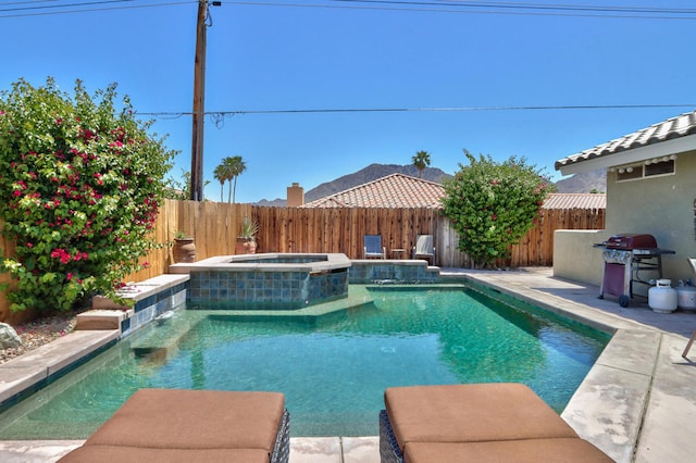 view of swimming pool with area for grilling and an in ground hot tub