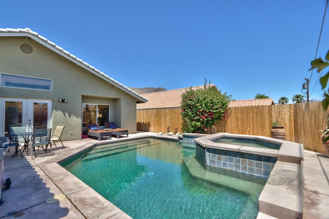 view of swimming pool with a patio area, an in ground hot tub, and french doors