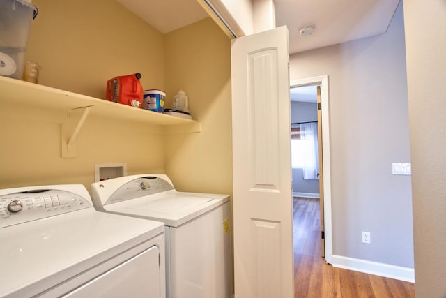 laundry area featuring washing machine and dryer and light hardwood / wood-style floors