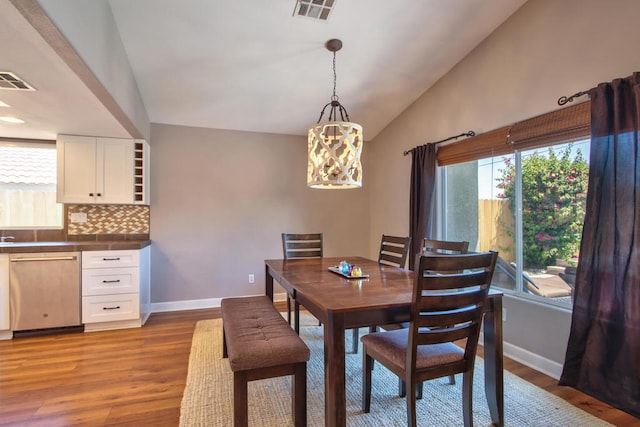 dining space featuring light hardwood / wood-style floors and vaulted ceiling