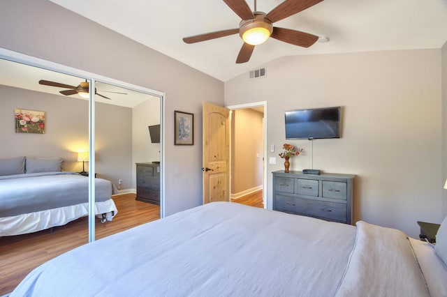 bedroom featuring lofted ceiling, a closet, ceiling fan, and light hardwood / wood-style floors