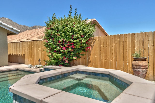 view of swimming pool with an in ground hot tub